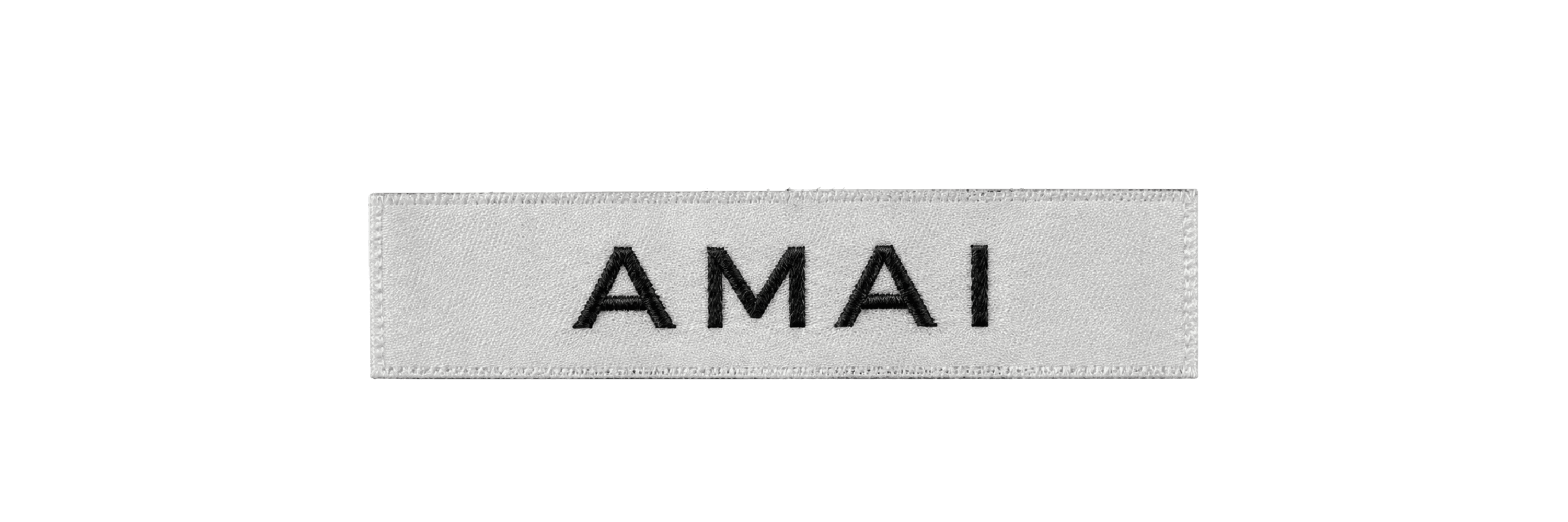 AMAI woven label: the wordmark in black on a light grey band.